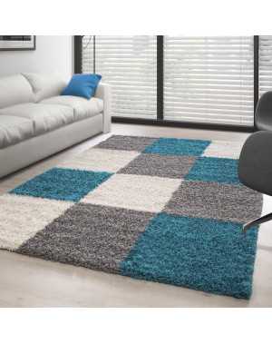 Hoogpolig vloerkleed met een turquoise-wit-grijs geblokt patroon.