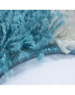 Hoogpolig vloerkleed met een turquoise-wit-grijs geblokt patroon.